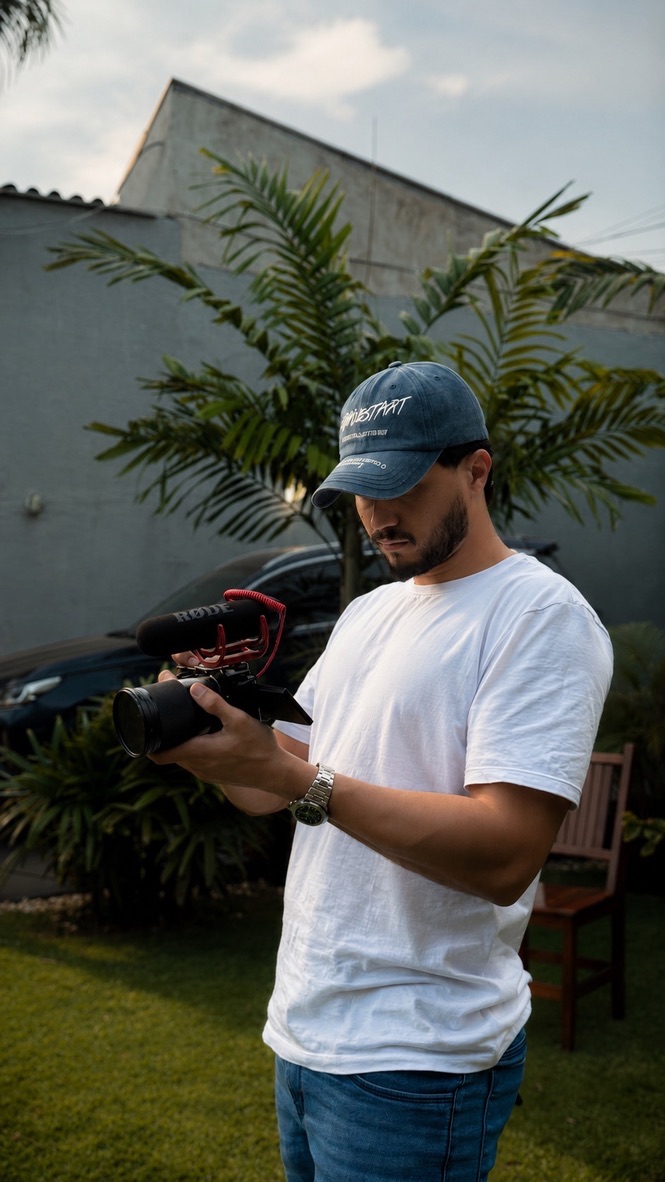 Jhonatan Maker operando uma câmera profissional durante uma produção audiovisual