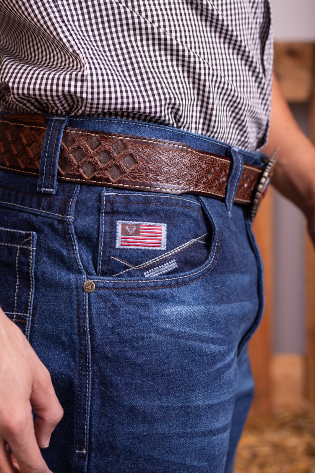 Detalhe fotográfico de jeans e cinto em couro