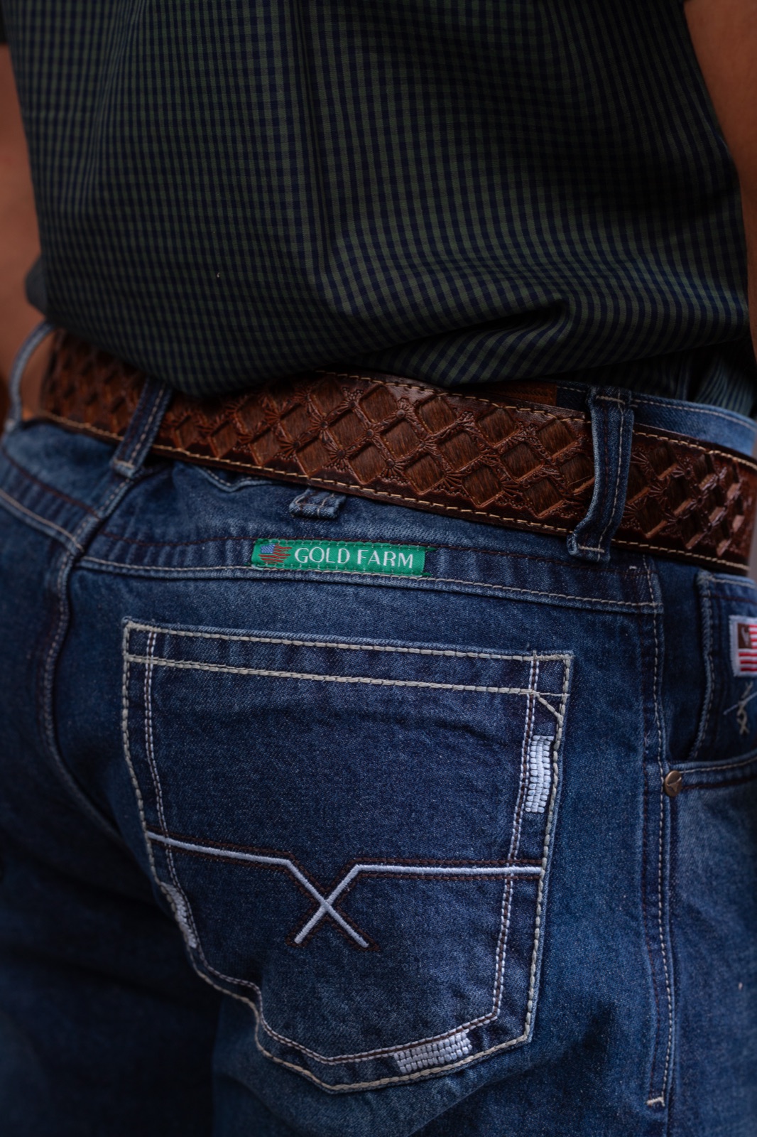 Detalhe fotográfico do acabamento de uma calça jeans