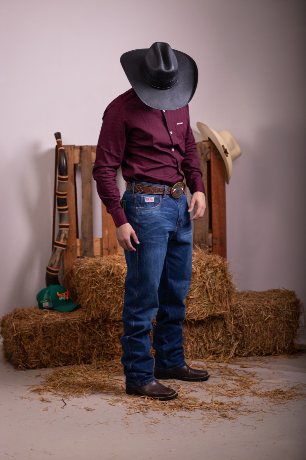 Jhonatan em ensaio de corpo inteiro com camisa vinho e traje country