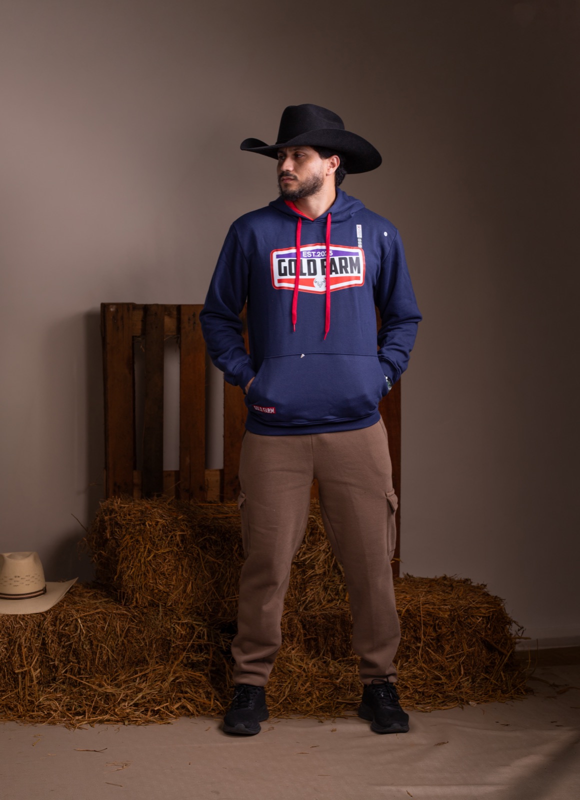 Jhonatan modelando moletom azul em cenário country